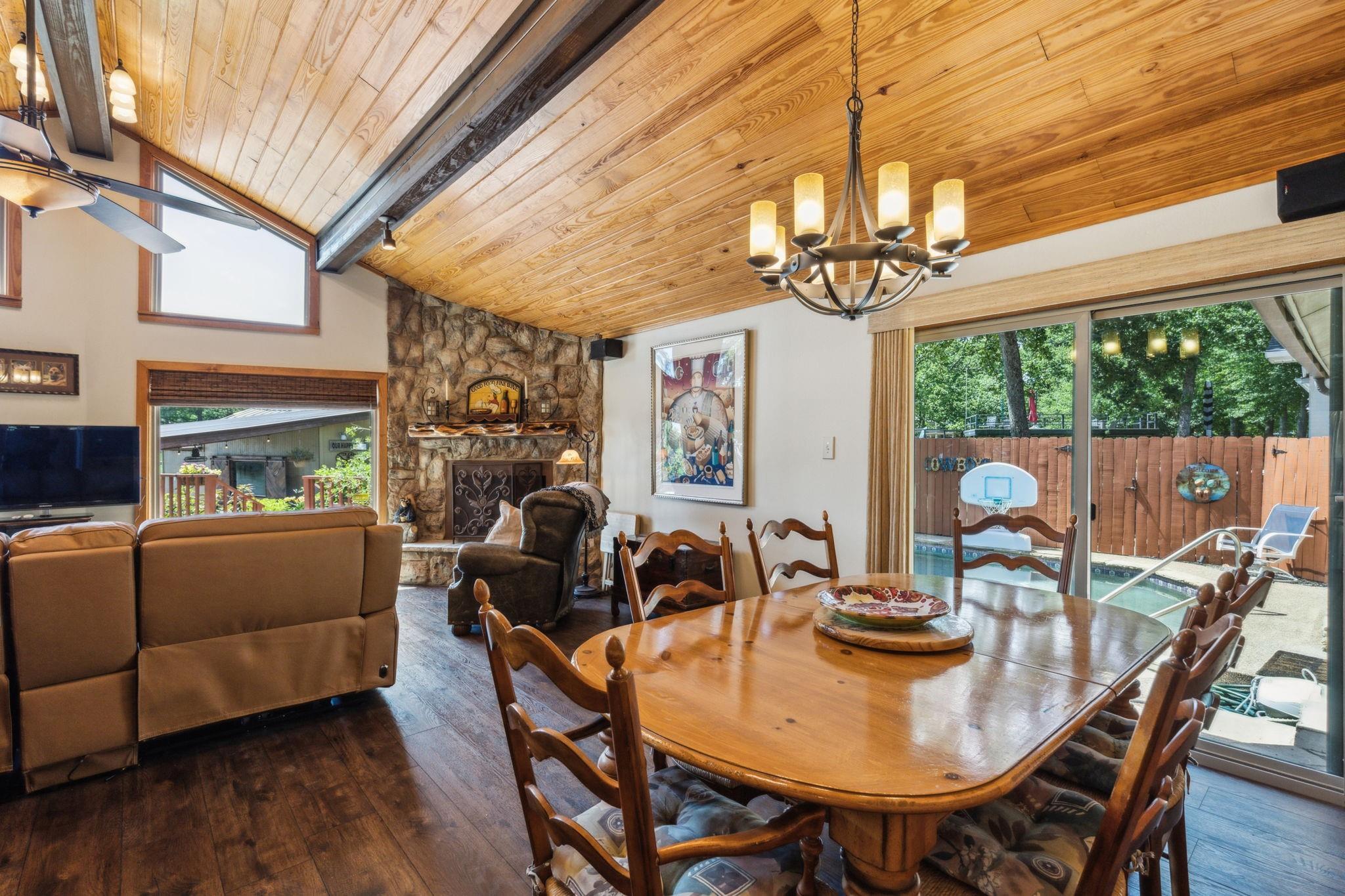 Dining area with stone fireplace and sliding doors to pool deck